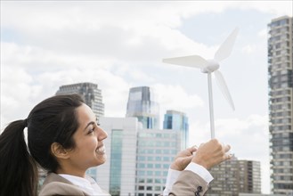 Asian businesswoman holding wind turbine model