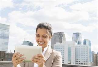 Asian businesswoman using digital tablet on urban balcony