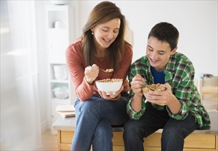 Caucasian mother and son eating cereal together
