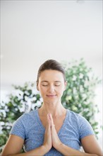 Serene Caucasian woman with hands in prayer position