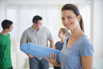 Portrait of smiling woman holding yoga mat