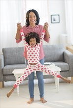 African American mother lifting daughter playfully