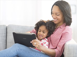 African American mother and daughter using digital tablet