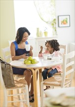 African American mother and daughter at breakfast table