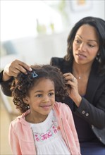 African American mother fixing daughter's hair