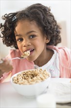 Portrait of African American girl eating cereal