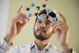 Mixed race businessman examining molecular model