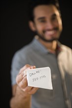 Mixed race man giving out phone number on napkin
