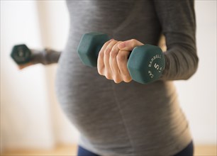 Pregnant Caucasian woman lifting weights