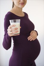 Pregnant Caucasian woman holding glass of milk