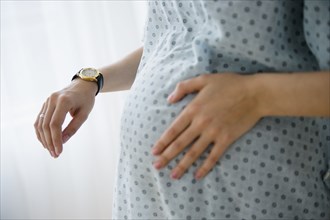 Pregnant Caucasian woman timing contractions in hospital