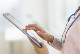 Hispanic nurse using digital tablet in hospital