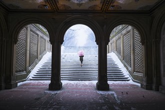 Asian woman walking up steps into snow