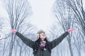 Asian woman cheering in snowy park