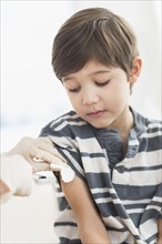 Hispanic boy getting a shot at doctor's office