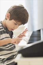 Hispanic boy practicing piano