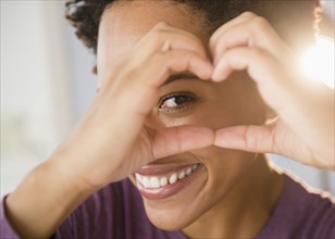 Close up portrait of Black woman forming heart-shape with hands