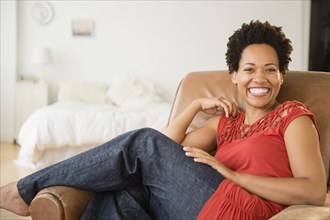Portrait of smiling Black woman in armchair