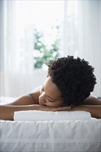 Serene Black woman laying on massage table