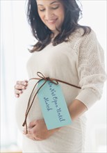 Pregnant Hispanic woman with gift wrap around belly