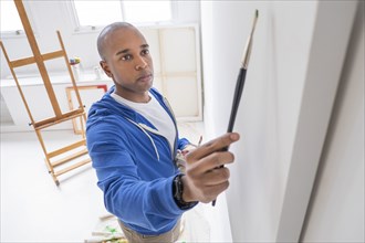 Black artist painting in studio