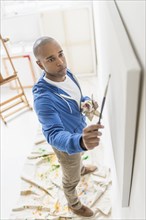 Black artist painting in studio