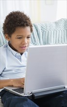 Black boy using laptop in living room