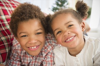 Black children smiling together on sofa