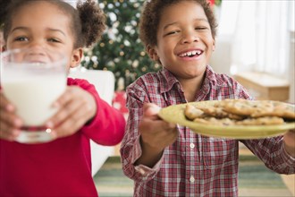 Black children with milk and cookies for Santa Claus