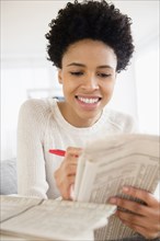 Black woman searching for jobs in newspaper