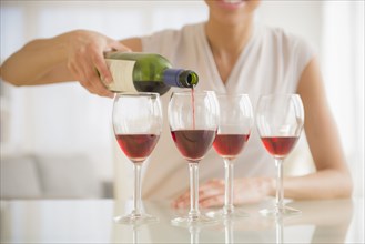 Black woman pouring glasses of wine
