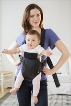 Mother carrying baby in sling