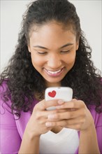 Mixed race woman using cell phone
