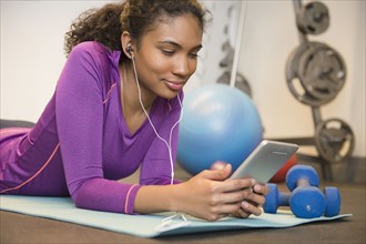 Mixed race woman using digital tablet to exercise