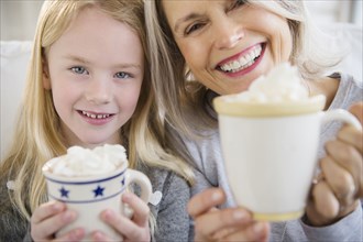 Senior Caucasian woman and granddaughter drinking hot cocoa