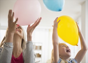 Senior Caucasian woman and granddaughter playing with balloons