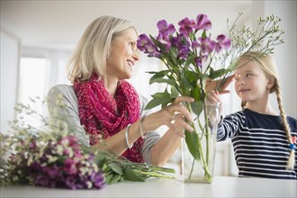 Senior Caucasian woman and granddaughter arranging flowers