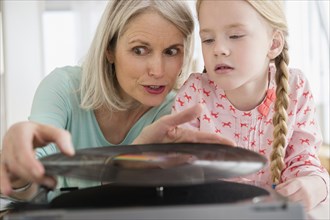 Senior Caucasian woman and granddaughter listening to records