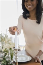 African American woman lighting candle