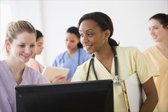 Nurses using computer together in hospital