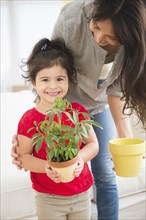 Hispanic mother and daughter gardening together