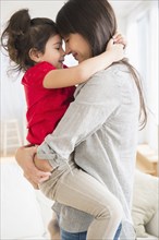 Hispanic mother and daughter hugging