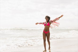 African American woman walking on beach