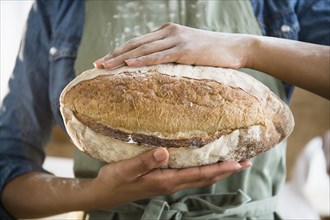 Mixed race woman holding loaf of bread