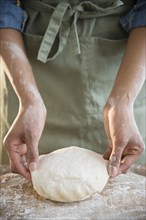 Mixed race woman kneading dough