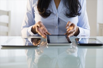 Mixed race businesswoman using digital tablets