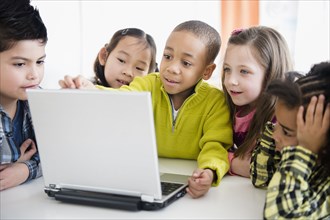 Children using laptop together