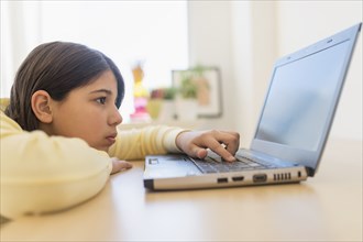 Hispanic girl using laptop at desk