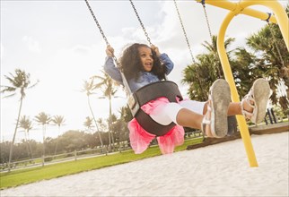 Mixed race girl playing on playground