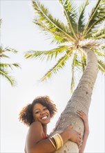Woman hugging palm tree outdoors
